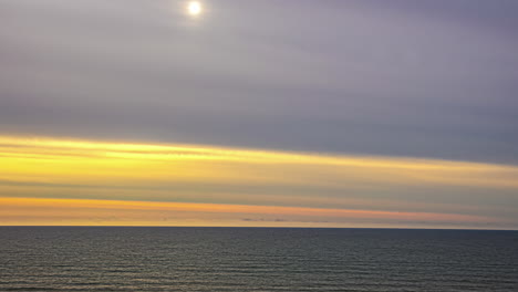 Yellow-sunrise-on-an-overcast-day-above-the-sea---time-lapse