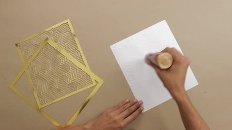 Gluing-piece-of-paper-to-put-golden-decorative-frames-on-it