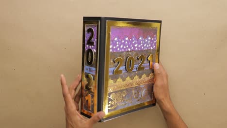 Turning-2021-scrapbook-lever-arch-file-with-golden-foil-cover-in-hands