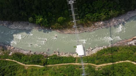 Luftaufnahme-Von-Oben-Nach-Unten-Des-Flusses-Und-Der-Hängebrücke-In-Nepal-An-Einem-Sonnigen-Tag