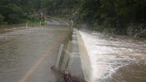 Mudgeeraba,-Gold-Coast,-2-De-Enero-De-2024:-Toma-Cercana-De-Una-Inundación-A-Través-Del-Puente-Del-Arroyo-Mudgeeraba-Que-Provocó-El-Cierre-De-La-Carretera