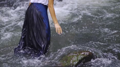 A-girl-touches-the-water-in-the-river-in-the-Salto-Encantado-park-located-in-Misiones,-Argentina