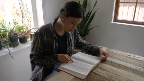 Puerto-ricanisches-Mädchen,-Das-Zu-Hause-Am-Schreibtisch-Die-Bibel-Liest-Und-Die-Heilige-Schrift-Liest