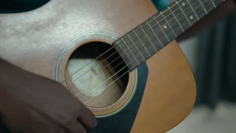 Detailaufnahme-Der-Hände-Eines-Jungen-Schwarzen-Mannes,-Der-Eine-Akustikgitarre-Spielt