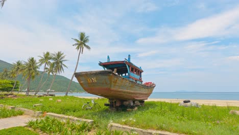 Old-Vintage-Vietnamese-Fishing-Boat-Abandoned-Near-Shoreline-Beach