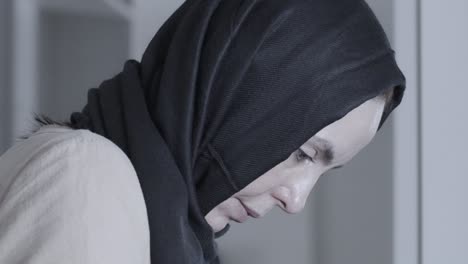 Muslimische-Frau-Schaut-Nach-Unten,-Während-Sie-Kleidung-Bügelt