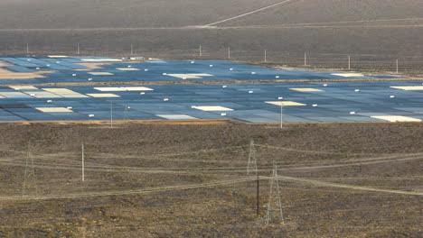 Solarpark-In-Der-Wüste-Von-Nevada-Hinter-Einem-Felsigen-Berg-Freigelegt,-Luftaufnahme