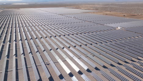 Sunlight-Glistening-on-Vast-Desert-Solar-Panel-Array,-Aerial