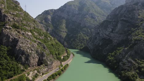 Drone-view-of-the-road-passing-by-the-Neretva-river-flowing-through-the-mountains-in-Bosnia