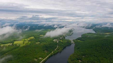 A-spectacular-4K-drone-shot-above-the-clouds-in-the-summer,-over-Parker-Pond-and-Pleasant-Lake,-located-in-Casco,-Maine,-USA