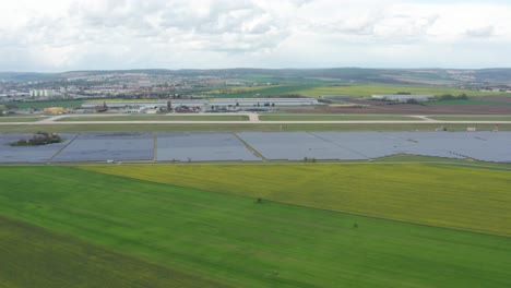 Huge-photovoltaic-solar-farm-by-the-airport,-aerial-view