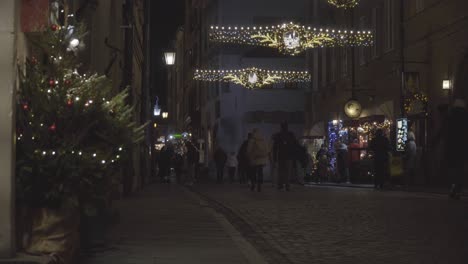 Christmas-decorations-on-a-street-in-Warsaw-Old-Town,-people-walking