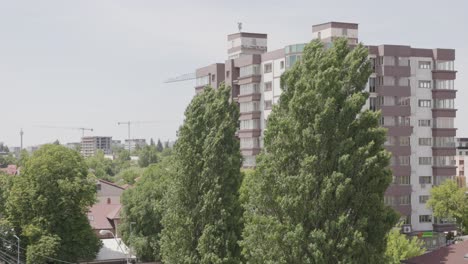 Cosbuc-Street,-Galati,-Romania---A-Sight-of-Residential-Structures-and-Towering-Trees---Wide-Shot