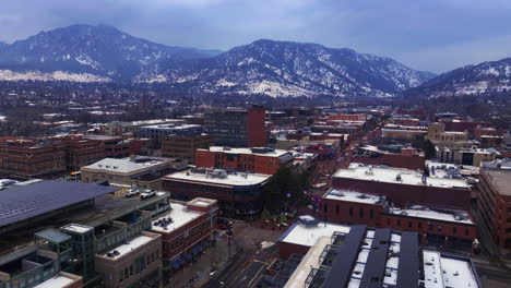 Christmas-in-Boulder-Colorado-Pearl-Street-Mall-cars-buildings-streets-Baseline-aerial-drone-cinematic-December-University-of-Colorado-CU-Buffs-Winter-cloudy-snowy-Flat-Irons-Chautauqua-Park-backward