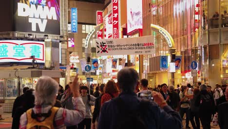 Statische-Zeitlupenaufnahme-Eines-Nächtlichen-Shibuya-Rennens-Mit-Menschen,-Die-Die-Straße-überqueren