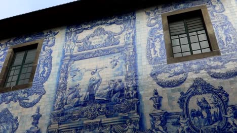 Jesus-life-scenes-represented-in-blue-tiles-in-Capela-das-Almas-exterior-facade,-Porto