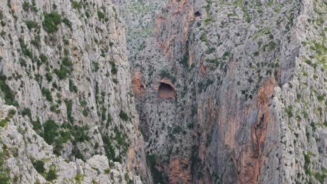 Aerial-Drone-In-Majorca,-A-Cave-Located-High-In-The-Mountains,-On-The-Side-Of-A-Cliff