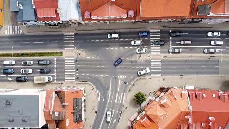 Busy-intersection-in-downtown-with-red-roof-buildings,-top-down-view
