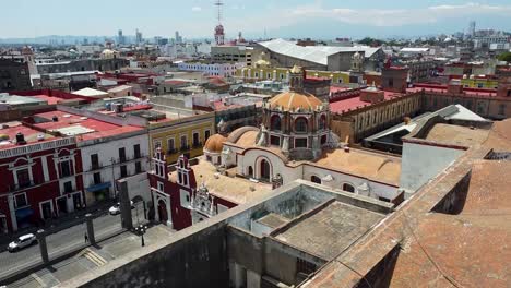 Aerial-tilt-down-shot-of-historic-cathedral-in-Puebla-City-during-sunny-day,-Mexico