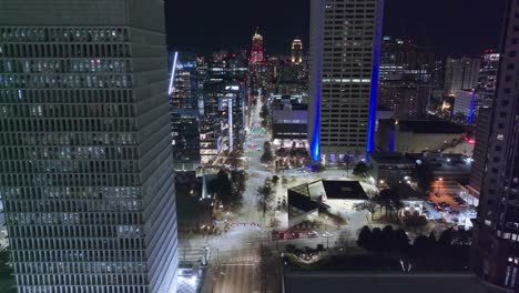Descending-drone-shot-of-main-road-in-Atlanta-Downtown-at-night-with-lighting-buildings,-USA