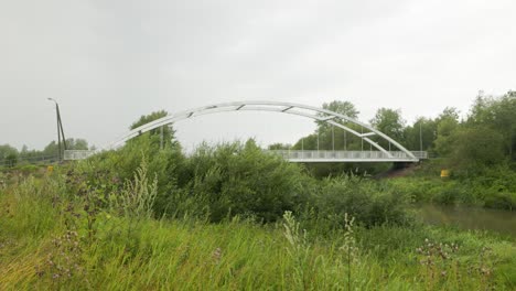 White-metal-bridge-crossing-a-stream