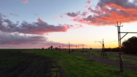 Wunderschöne-Sonnenuntergangsantenne,-Drohnenaufnahme-Von-Eisenbahnschienen-Im-Ackerland-Des-Freistaats,-Südafrika