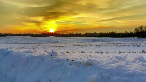 Golden-sunset-over-a-forest-and-snowy-field---pullback-sliding-motion-time-lapse