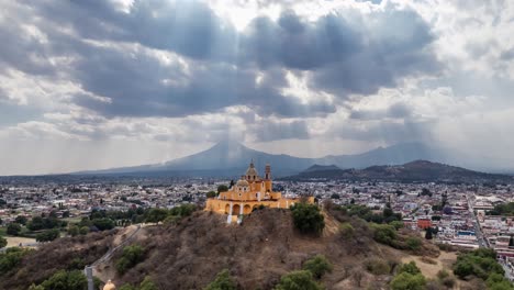 aerial-shot-showcases-a-stunning-hilltop-church-with-striking-golden-domes-and-twin-spires,-exuding-an-air-of-historical-reverence-and-architectural-splendor-in-Mexico