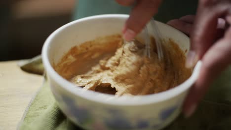 Thick-peanut-butter-hand-made-paste-whisked-in-bowl,-filmed-as-close-up-slow-motion-shot