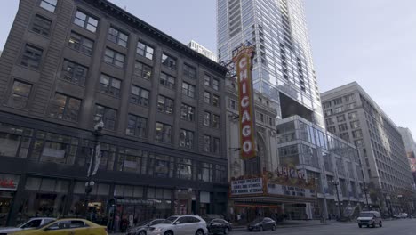 Panning-shot-of-Chicago's-theater-district,-showcasing-the-iconic-Chicago-Theatre-sign-and-bustling-city-life