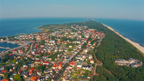 Drone-flying-above-Jastarnia-city-in-Poland-at-sunny-summer-day-with-baltic-sea-in-the-background