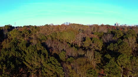 Aufsteigende-Drohnenaufnahme-Zeigt-Den-Wunderschönen-Park-Auf-Der-Westseite-Bei-Sonnenuntergang-Mit-Der-Skyline-Von-Atlanta-Im-Hintergrund
