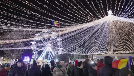 Una-Multitud-De-Personas-En-El-Parque,-Iluminadas-Con-Luces-Festivas,-Celebrando-El-Día-Nacional-De-Galati-En-Rumania---Toma-Estática