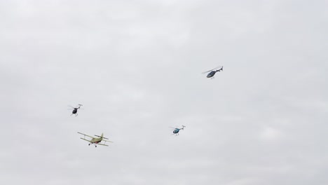 Agricultural-aircraft-in-flight-during-airshow-and-helicopters-fly-aside
