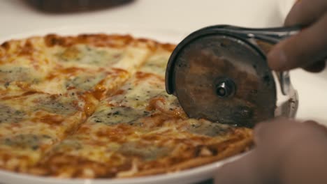 A-small-pizza-is-sliced-using-a-circular-pizza-cutter
