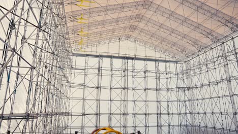 panning-tilt-up-shot-of-a-large-tent-structure-held-up-by-scaffold