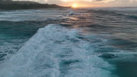An-aerial-drone-video-captures-the-enchanting-golden-hour-sunset-in-Hawaii,-revealing-a-stunning-view-of-big-ocean-waves-breaking