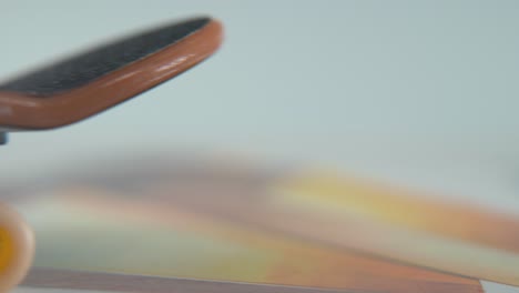 A-hyper-close-up-macro-detailed-shot-of-a-mini-skateboard,-tiny-white-wheels,-riding-fingerboard-from-right-to-left,-finger-slide,-professional-lighting,-dreamy-static-cinematic-4K-video