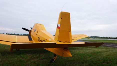 Old-yellow-soviet-build-airplane-on-airport-green-grass-field-during-airshow