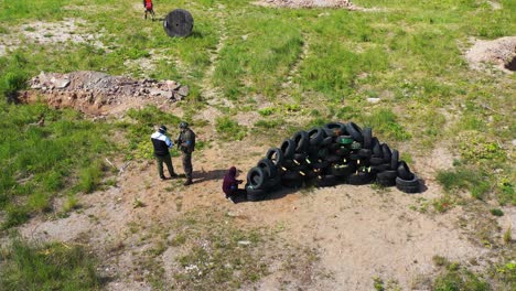 Airsoft-tactical-unit-team-decide-best-attack-strategy-near-pile-of-tires