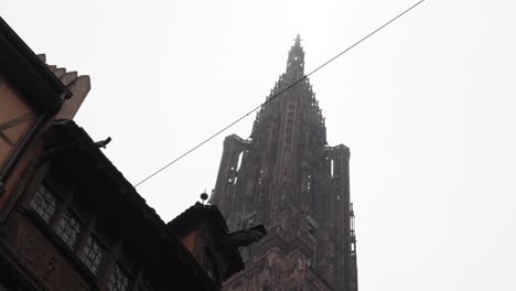 Die-Straßburger-Kathedrale-Vor-Dem-Hintergrund-Eines-Bewölkten-Himmels,-Die-Aufwendig-Verzierte-Fassade-Mit-Ihren-Meisterhaft-Geschnitzten-Details,-Beherbergt-Eine-Reihe-Von-Skulpturen,-Die-Szenen-Aus-Dem-Mittelalterlichen-Leben-Darstellen