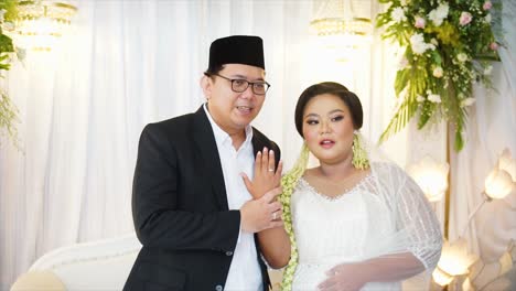 Hände-Des-Bräutigams-Und-Der-Braut,-Die-Auf-Einer-Indonesischen-Hochzeitsfeier-Eheringe-Tragen-Und-Zeigen,-Sie-Tragen-Traditionelle-Hochzeitskleider-Aus-Indonesien