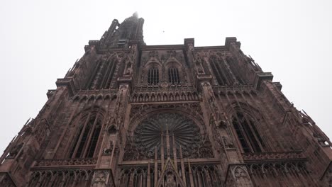 The-Strasbourg-Cathedral-against-a-cloudy-sky-backdrop,-the-intricately-adorned-facade-beckons-with-an-array-of-sculptures-portraying-scenes-from-the-Bible-and-medieval-life