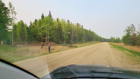 POV-Window-Seat-View-of-a-Forest-Fire-Landscape-with-Workmen-at-Dusty-Road