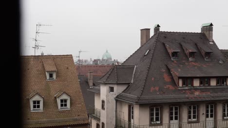Gazing-upon-the-rooftops-of-Strasbourg-on-a-misty-and-atmospheric-day,-the-captivating-panorama-unfolds-with-a-harmonious-fusion-of-both-German-and-French-architectural-styles