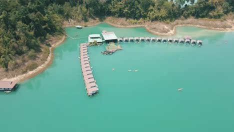 Imágenes-En-Cámara-Lenta-De-Personas-Navegando-En-Kayak-Por-Bungalows-En-El-Lago-Cheow-Lan,-Tailandia