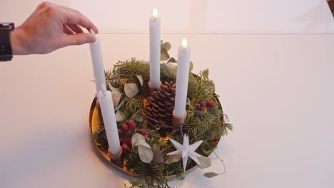 Turning-Off-Electric-Candles-on-Christmas-Advent-Wreath-White-Background