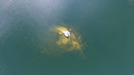 Eine-Spektakuläre-4K-Drohnenaufnahme-Eines-Kanus,-Das-Auf-Einer-Kleinen-Felseninsel-Mitten-Im-Parker-Pond-In-Casco,-Maine,-USA,-Angedockt-Ist