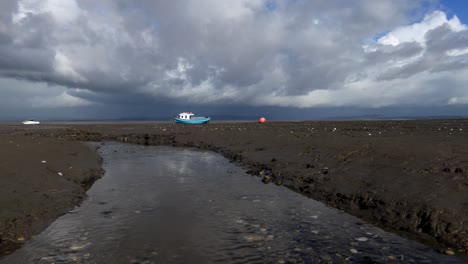 Morecambe-Bay,-Blaues-Boot-Und-Wütende-Wolken