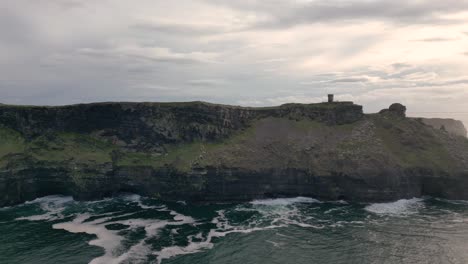 Cinematic-aerial-view-of-Moher-Tower-at-Hag's-Head-and-Ireland-Cliffs-at-sunset